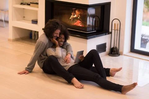 Multiethnic couple using tablet computer on the floor beautiful young mult... Stock Photos