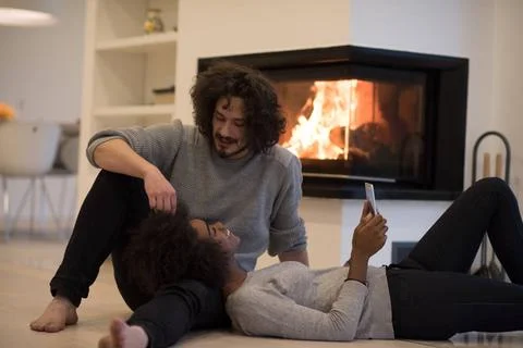 Multiethnic couple using tablet computer on the floor beautiful young mult... Stock Photos