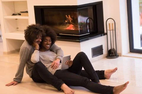 Multiethnic couple using tablet computer on the floor beautiful young mult... Stock Photos