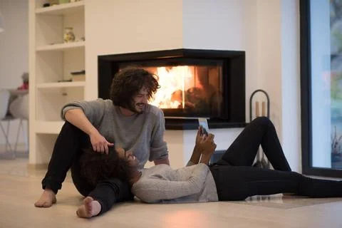 Multiethnic couple using tablet computer on the floor beautiful young mult... Stock Photos