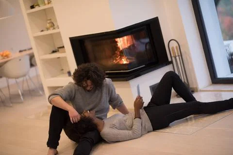 Multiethnic couple using tablet computer on the floor beautiful young mult... Stock Photos