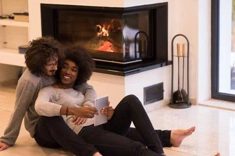Multiethnic couple using tablet computer on the floor beautiful young mult... Stock Photos