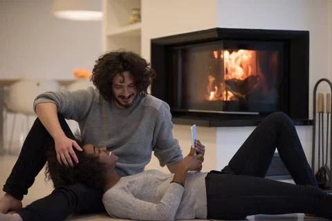 Multiethnic couple using tablet computer on the floor beautiful young mult... Stock Photos