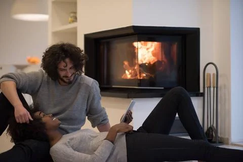 Multiethnic couple using tablet computer on the floor beautiful young mult... Stock Photos