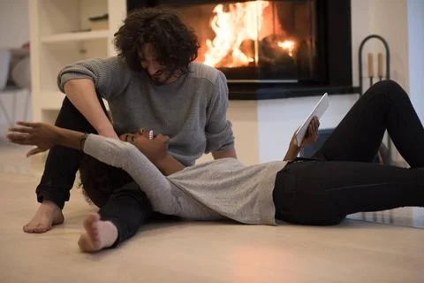 Multiethnic couple using tablet computer on the floor beautiful young mult... Stock Photos