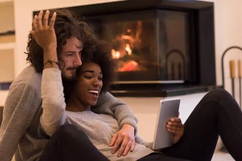 Multiethnic couple using tablet computer on the floor beautiful young mult... Stock Photos