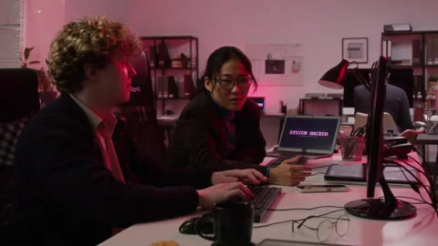 Multiethnic Cybersecurity Analysts Dealing with System Hack in Office Stock Footage 347312102