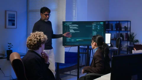 Multiethnic Cybersecurity Team Analyzing Code on Monitor in Office Stock Footage 347298348