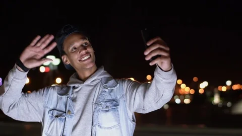 Multiethnic dark-skinned guy make videocall on his device and say hello Stock Footage 115757790