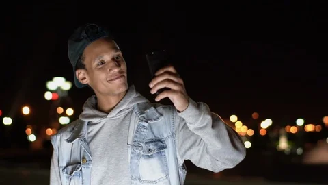 Multiethnic dark-skinned guy take some selfies on his smartphone, 2x slowmotion Stock Footage 115748364