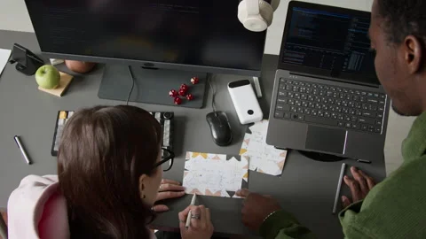 Multiethnic Developers Brainstorming while Drawing Block Scheme for Project Stock Footage 335940854