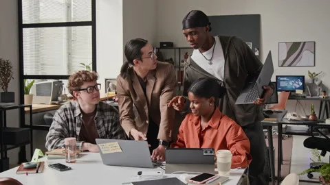 Multiethnic Developers Collaborating on Laptop in Modern Office Stock Footage 336713337