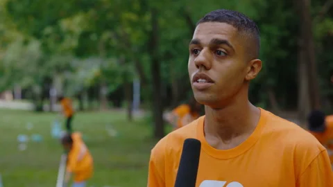 Multiethnic Eco Activist Is Giving the Interview Standing on the Group of Stock Footage 235659943