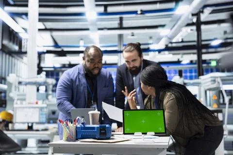 Multiethnic energy specialists coordinates activity next to chroma key Stock Photos