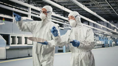 Multiethnic engineering team coworkers carry silicon wafer in microchip factory Stock Footage 333393824