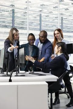 Multiethnic engineering team examining microchip circuit design on PC Stock Photos
