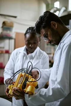 Multiethnic Engineers Assembling Robotic Device in Modern Lab Stock Photos