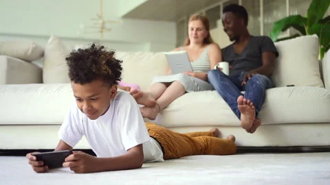 Multiethnic family using devices and having good time together in apartment room Stock Footage 151734153