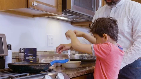 Multiethnic father and son making eggs 10 Stock Footage 89351375