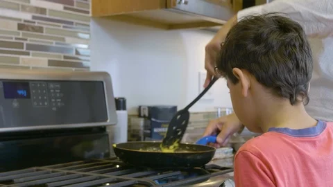 Multiethnic father and son making eggs 8 Stock Footage 89351477