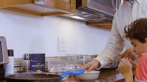 Multiethnic father and son making eggs 9 Stock Footage 89351495