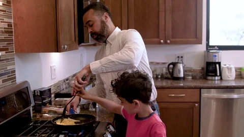 Multiethnic father and son making eggs 2 Stock Footage 89352317