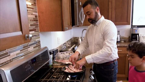 Multiethnic father and son making bacon Stock Footage 89353467