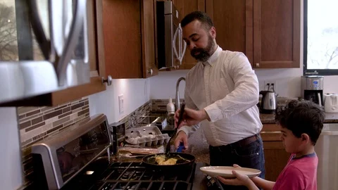 Multiethnic father and son making eggs 4 Stock Footage 89353487