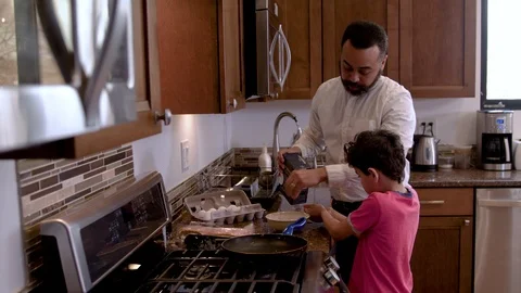 Multiethnic father and son making eggs 3 Stock Footage 89353524