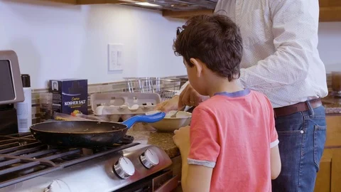 Multiethnic father and son making eggs 11 Stock Footage 89353527