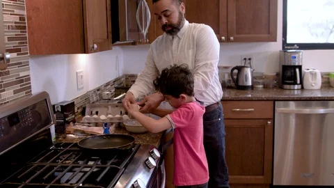 Multiethnic father and son making eggs 1 Stock Footage 89353533