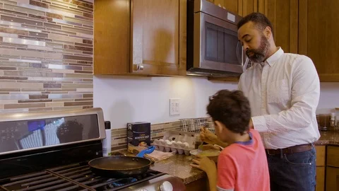 Multiethnic father and son making eggs 5 Stock Footage 89355747