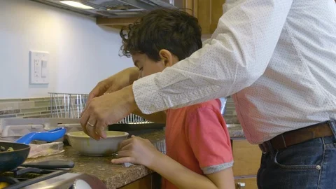 Multiethnic father and son making eggs 7 Stock Footage 89358378