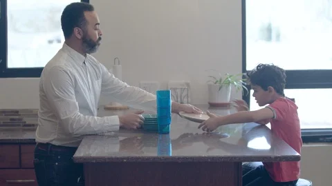 Multiethnic father and son setting the table 1 Stock Footage 89351124