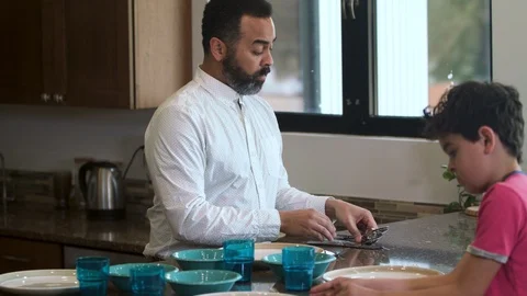 Multiethnic father and son setting the table 2 Stock Footage 89355322