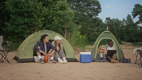 Multiethnic Friends Camping on Beach While Working on Laptop Stock Footage 343254454