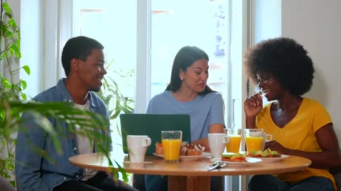 Multiethnic friends doing online shopping with the computer while having br.. Stock Footage 235906249