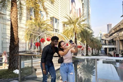 Multiethnic friends grimacing while taking a selfie outside a mall in Asia Stock Photos