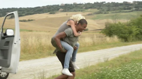 Multiethnic friends have fun coming out van in farmland fields Stock Footage 64519978