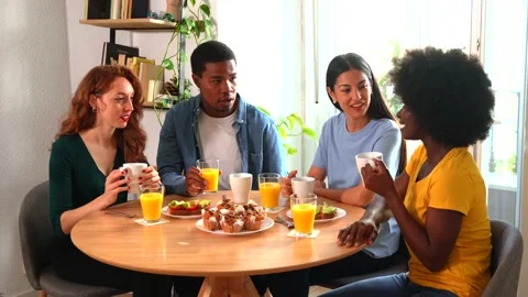 Multiethnic friends having fun at a breakfast with orange juice and muffins.. Stock Footage 235906593