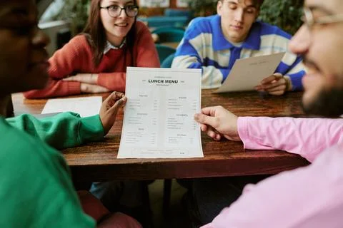 Multiethnic Friends Reading Lunch Menu Together in Cafe Stock Photos