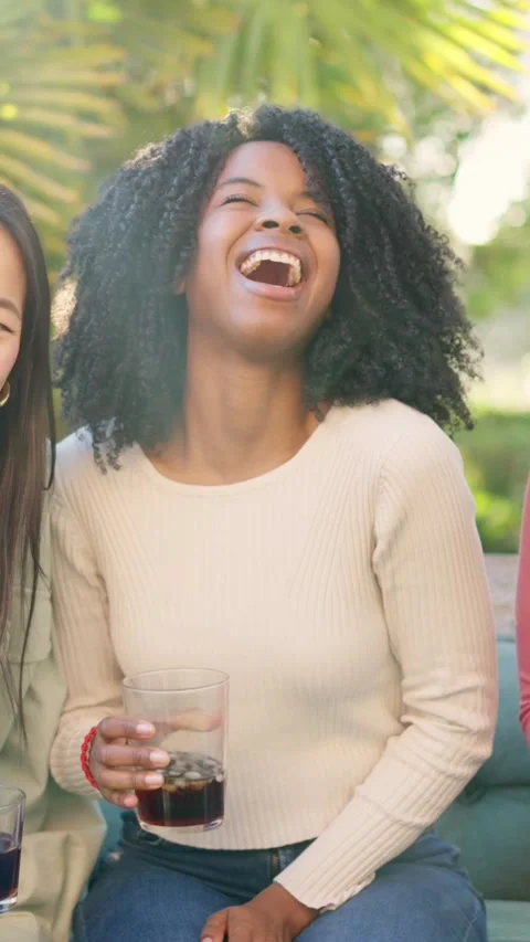 Multiethnic friends smiling at camera while drinking in the garden Stock Footage 269770301