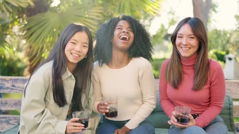 Multiethnic friends smiling at camera while drinking in the garden Stock Footage 270405098
