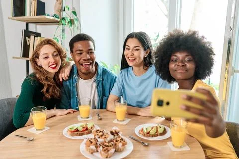 Multiethnic friends taking a selfie while having breakfast at home Stock Photos