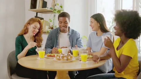 Multiethnic friends talking while having breakfast at home Stock Footage 238026602