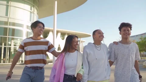 Multiethnic friends walking down the street holding each other affectionately. Stock Footage 164777975