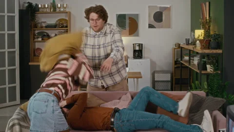 Multiethnic Group of Friends Having Playful Pillow Fight on Sofa Stock Footage 340279538