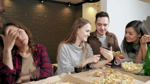 Multiethnic group of friends looking at smartphone and discussing something Stock Footage 148094277
