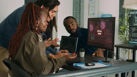 Multiethnic group of it engineers dealing with hacking alert Foto stock