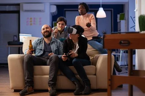 Multiethnic group of people having fun with video games on console Stock Photos
